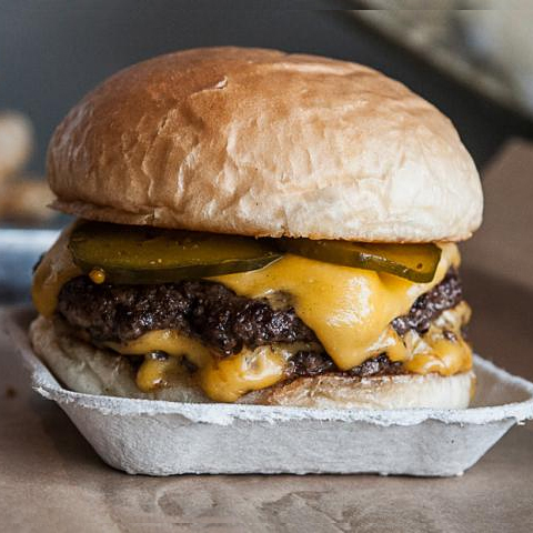The Company Burger - two thin patties of house-ground Creekstone Prime beef, homemade bread and butter pickles, red onions, American Cheese and our toasted bun.